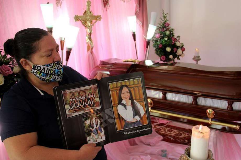 Gloria Riascos sostiene hoy fotografías de su hija Laura Michel Melo Riascos, una de las víctimas de la masacre de nueve jóvenes, en Samaniego (Colombia).