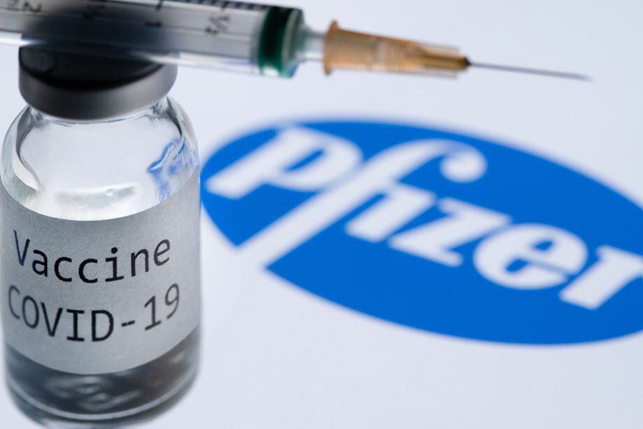 (FILES) In this file photo taken on November 23, 2020 This illustration picture taken in Paris on November 23, 2020 shows a syringe and a bottle reading "Covid-19 Vaccine" next to the Pfizer company logo. - Britain on December 2, 2020 became the first country to approve Pfizer-BioNTech's Covid-19 vaccine for general use and said it would be introduced next week. (Photo by JOEL SAGET / AFP)