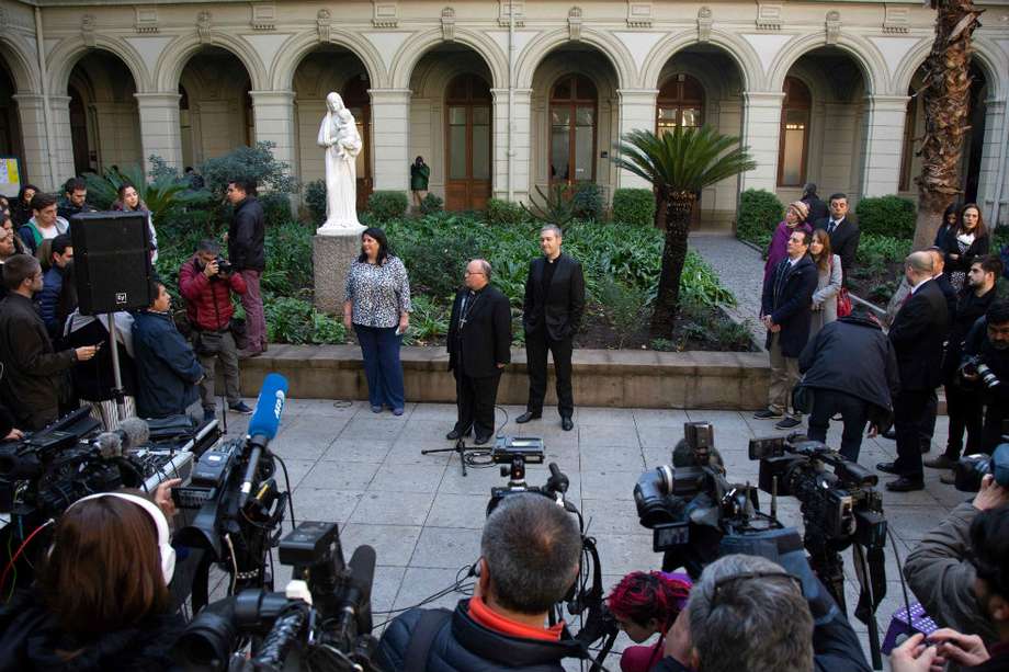 El arzobispo maltés Charles Scicluna (i), enviado especial del papa Francisco a Chile, ofrece declaraciones acompañado del sacerdote español Jordi Bertomeu. / AFP