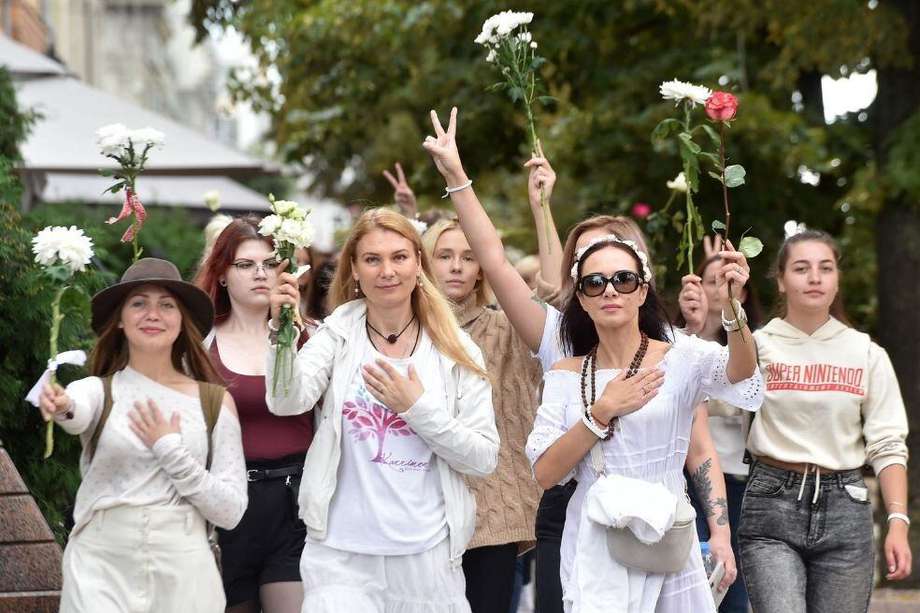 Un grupo de mujeres sostiene flores para protestar contra la violencia de la policía hacia los manifestantes en Bielorrusia.