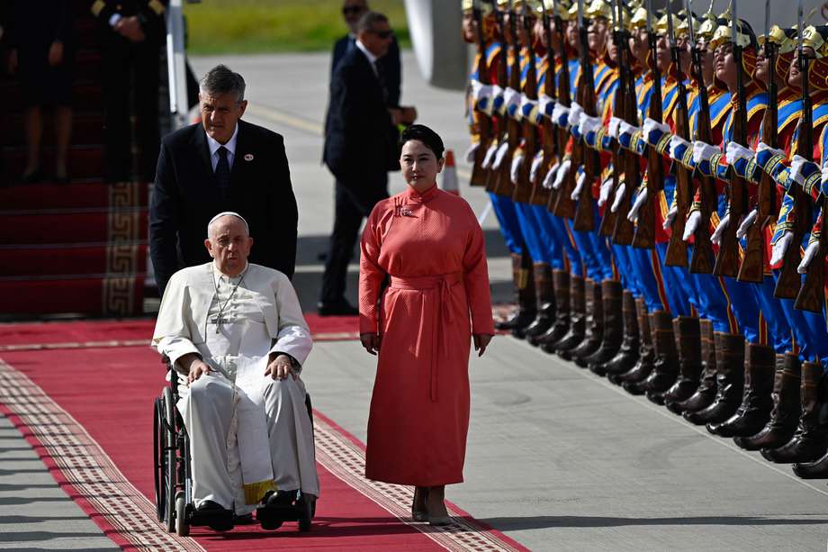 El Papa Francisco es recibido por el ministro de Asuntos Exteriores de Mongolia, Batmunkh Battsetseg (derecha, en rojo), durante su llegada al aeropuerto internacional Chinggis Khaan de Ulán Bator.