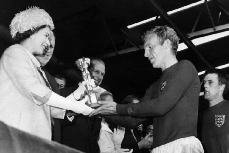 La reina Isabel de Inglaterra entrega la copa de campeón del Mundo de 1966 a Bobby Moore.