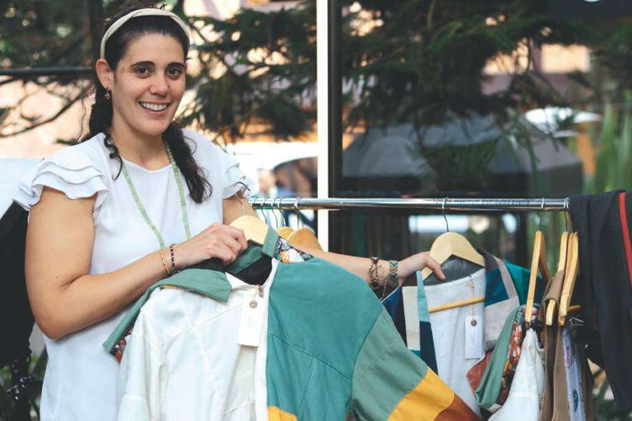 Ana Karina García, directora de la fundación Juntos se Puede, junto a las prendas elaboradas por mujeres de la organización. 