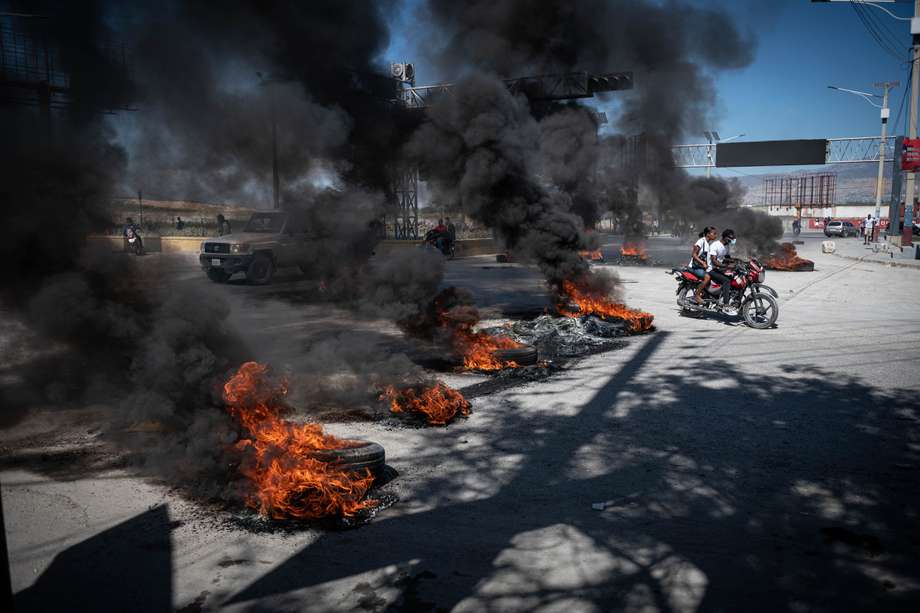 Personas transitan por una calle con bloqueos en el marco de las protestas hoy, en Puerto Príncipe (Haití). 