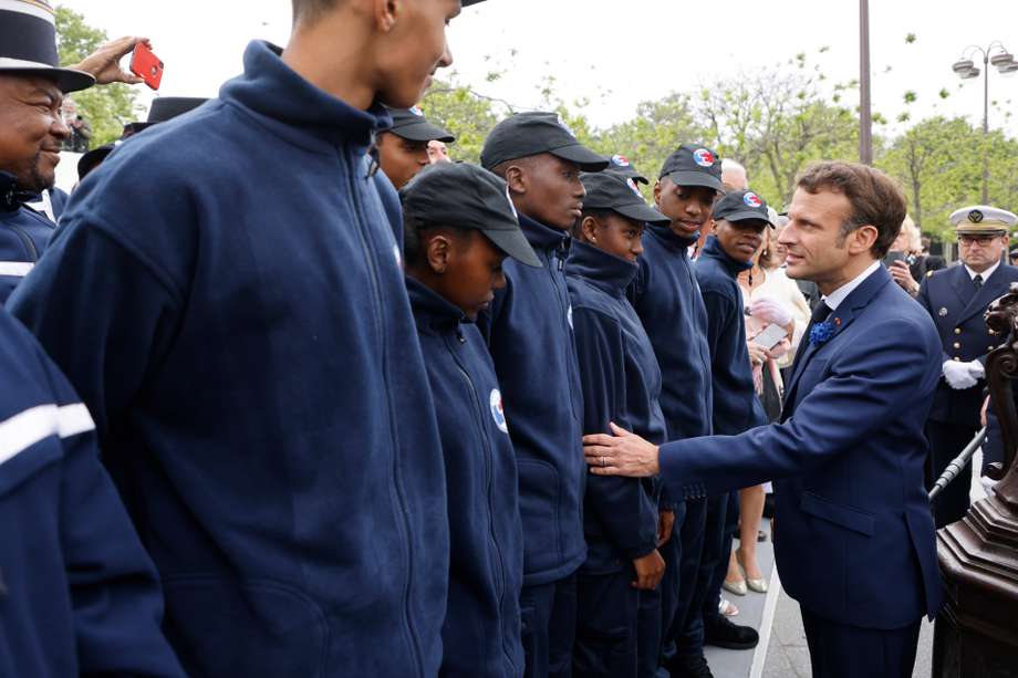 El presidente de Francia, Emmanuel Macron (d), saluda a los cadetes de la gendarmería mayotense (i) en el Arco del Triunfo mientras asisten a las ceremonias que marcan la victoria aliada contra la Alemania nazi y el final de la Segunda Guerra Mundial en Europa, en París, Francia, 08 de mayo 2022.