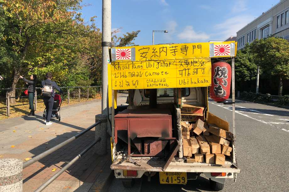 Venta ambulante de batata asada, con cartel en nueve idiomas, en el barrio de Odaiba en Tokio.