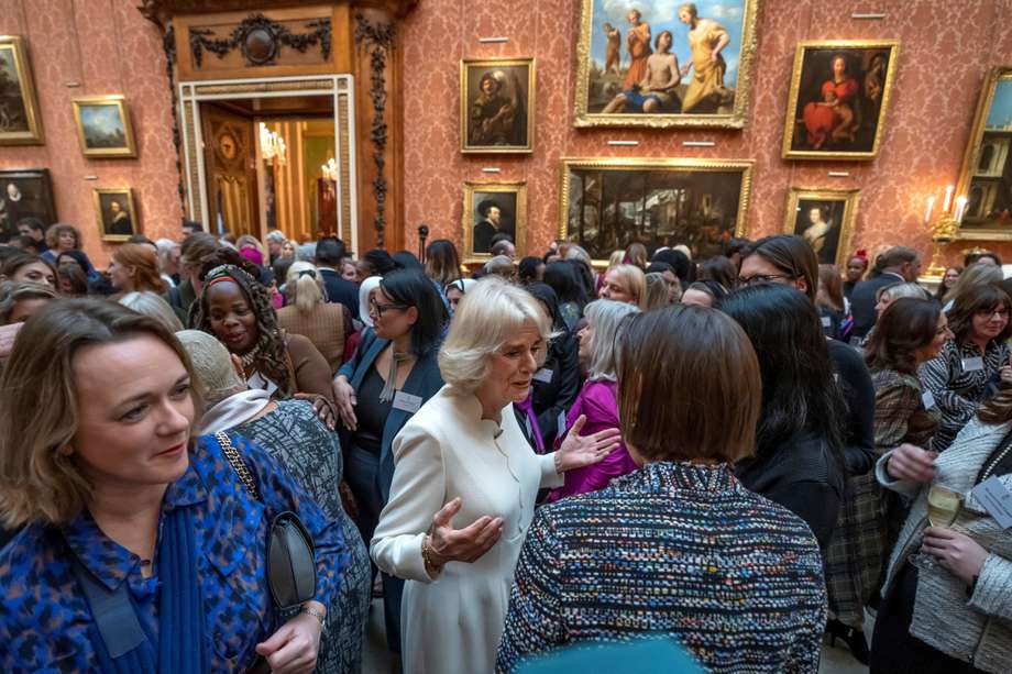La reina consorte británica Camilla (derecha) habla con los invitados cerca de Ngozi Fulani (atrás a la izquierda), directora ejecutiva del grupo Sistah Space con sede en Londres, durante una recepción para crear conciencia sobre la violencia contra las mujeres y las niñas.
