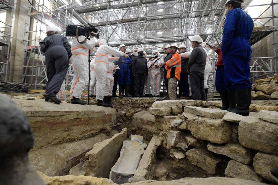 La ministra de Cultura de Francia, Roselyne Bachelot (C, izquierda) visita el sitio de investigación arqueológica de la Catedral de Notre Dame después del descubrimiento de un sarcófago de plomo del siglo XIV, en París, el 15 de marzo de 2022. (Foto de JULIEN DE ROSA / AFP)