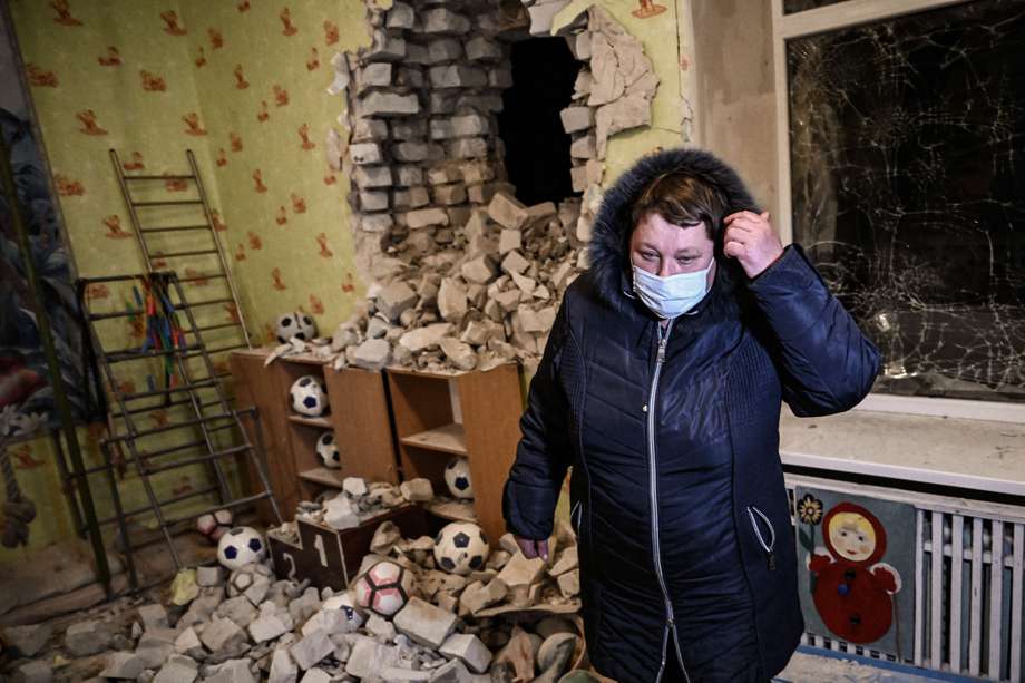 Una mujer en medio de los escombros dejados por el bombardeo en el jardín infantil.