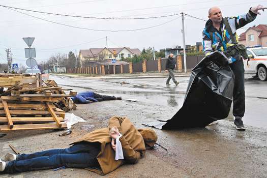 El cuerpo de un hombre con las manos atadas antes de ser retirado en una bolsa.  / AFP