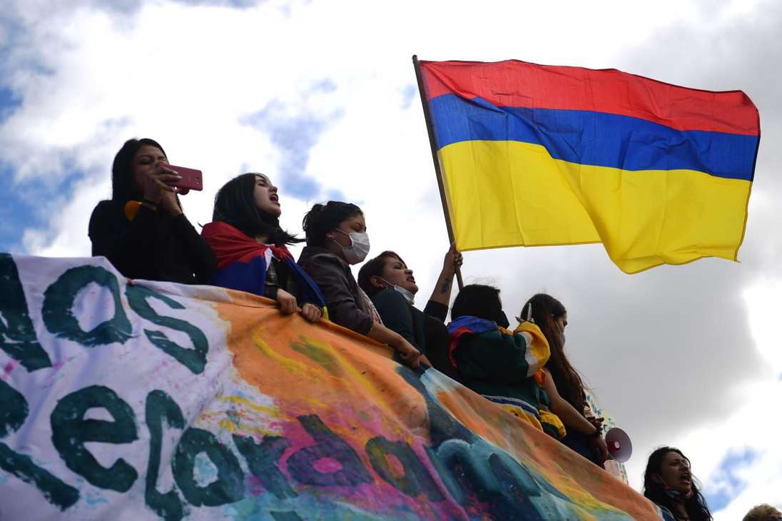 Varias mujeres sostienen una bandera de Colombia