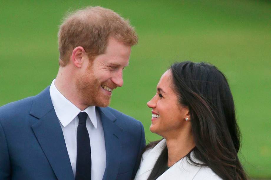 TOPSHOT - Britain's Prince Harry and his fiancée US actress Meghan Markle pose for a photograph in the Sunken Garden at Kensington Palace in west London on November 27, 2017, following the announcement of their engagement. Britain's Prince Harry will marry his US actress girlfriend Meghan Markle early next year after the couple became engaged earlier this month, Clarence House announced on Monday. / AFP / Daniel LEAL-OLIVAS
