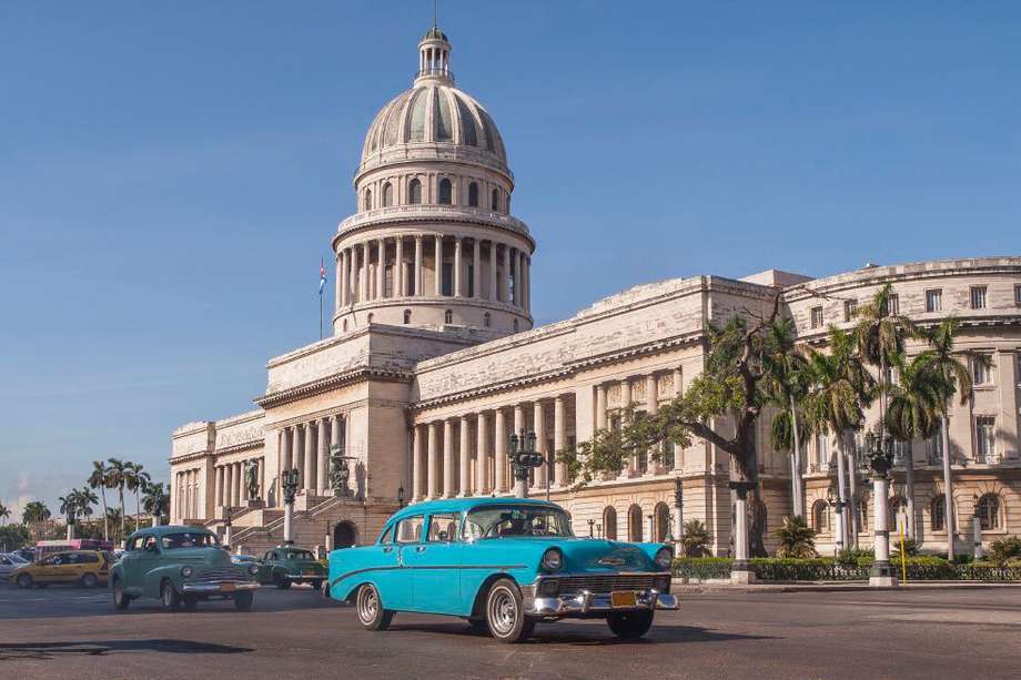 old American cars passing in front of the Capitolio in Havana, Cuba