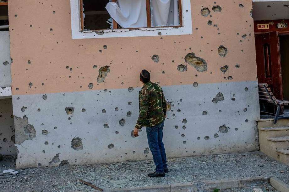 Movsumov Qowkar, de 32 años, revisa la casa de su vecino dañada por los bombardeos durante los combates en la región separatista de Nagorno-Karabaj.