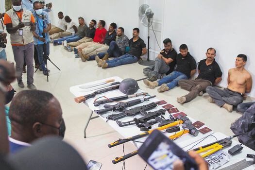 FILE - In this July 8, 2021 file photo, suspects in the assassination of Haiti's President Jovenel Moise are shown to the media, along with the weapons and equipment they allegedly used in the attack, at police headquarters in Port-au-Prince, Haiti. Haitian authorities have implicated at least 20 retired Colombian soldiers in the president's assassination on July 7. (AP Photo/Odelyn Joseph, File)