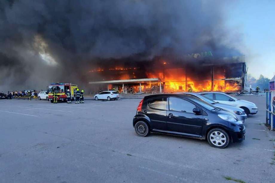 Los bomberos y servicios de rescate extinguen un incendio en un centro comercial en Kremenchuk, Ucrania, que recibió un misil ruso el martes.