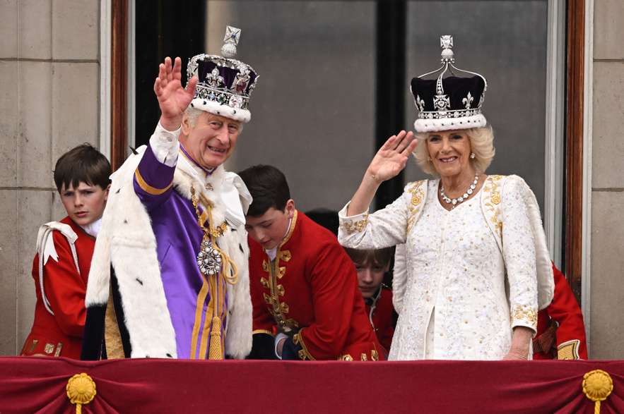 El rey Carlos III de Gran Bretaña con la corona del estado imperial y la reina Camila de Gran Bretaña, saludan desde el balcón del Palacio de Buckingham