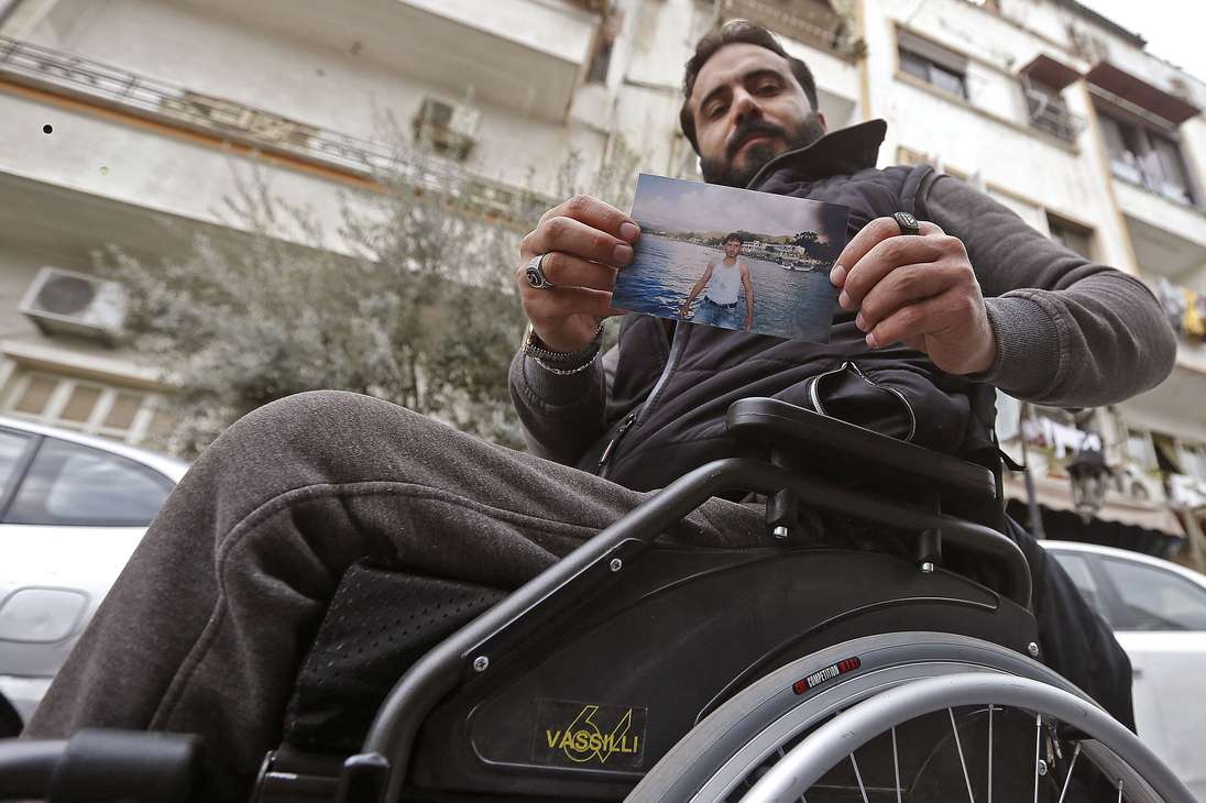 Samer al-Sawwan, un sirio de 33 años, posa para una foto en la capital, Damasco, mientras sostiene una foto de sí mismo de diez años antes de pie en una playa en la localidad costera de Latakia. El vehículo de Sawwan fue atravesado por una bala mientras conducía en 2011, lo que hizo que el vehículo rodara como un barril que lo paralizó para siempre. "Me desmayé con dos piernas y me desperté en una silla de ruedas", dice. "Mis ambiciones y mis sueños han cambiado".
