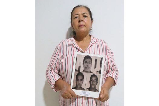 Yaneth Zamudio sostiene el retrato de sus familiares desaparecidos.