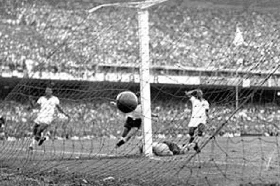 Alcides Ghiggia, tapado por uno de los postes del arco que defendía Moacyr Barbosa, comienza su carrera de celebración por el segundo gol de su equipo contra Brasil, obra suya, en la final de la Copa del Mundo de 1950. / Archivo