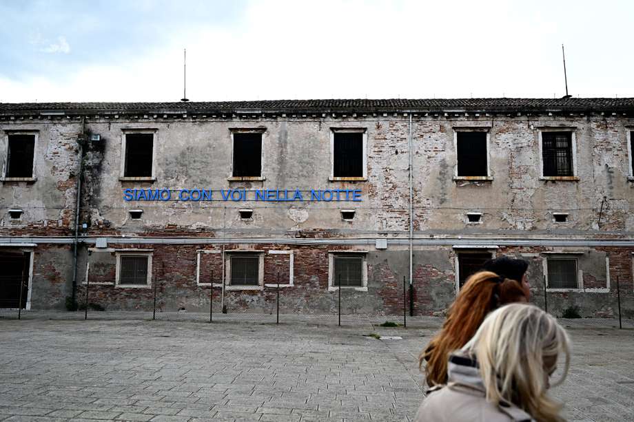 Un mensaje en neón azul colgado en la pared de una fachada llama a los visitantes: "Siamo con voi nella notte" ("Estamos con ustedes por la noche"), un eslogan originado en Florencia y utilizado en Italia en los años 1970 en apoyo de los presos políticos.