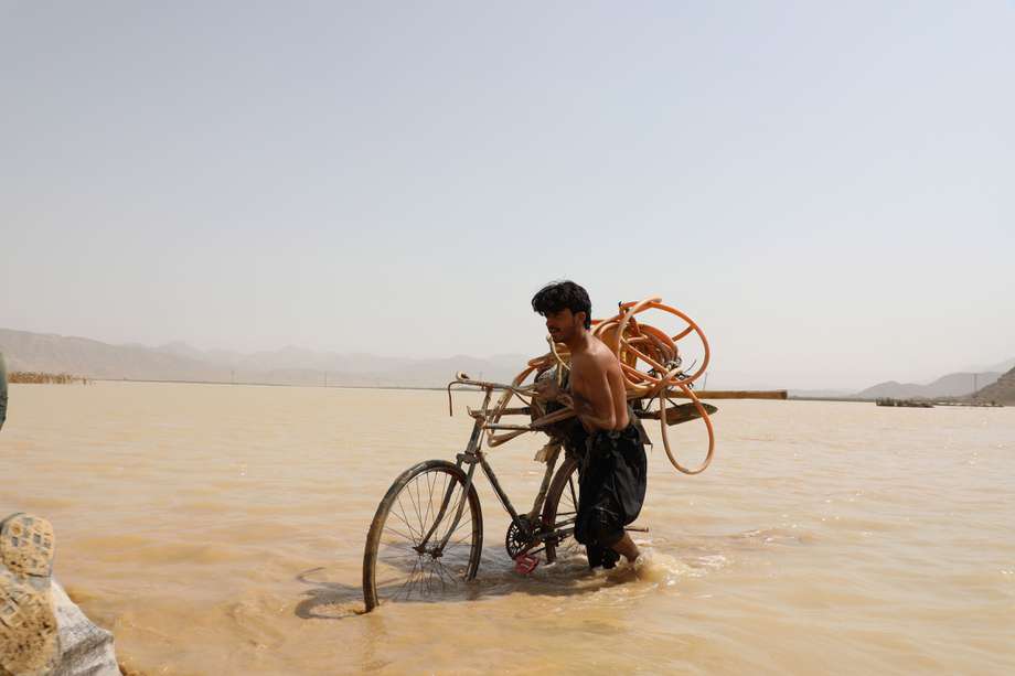 Unciclista en Mastung , provincia de Balochistan en Pakistan, intenta cruzar por las inundaciones que han provocado los monzones por todo el país y que han dejado 1.400  personas muertas. EFE/EPA/JAMAL TARAQAI
