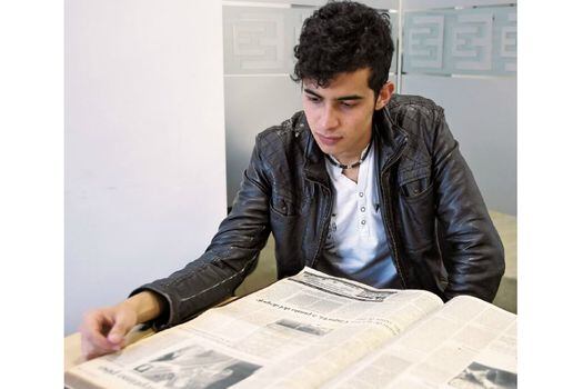 Iván Calderón Alvarado revisando la edición del periódico El Espectador del día en que murieron sus padres. / Óscar Pérez