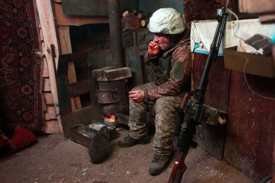 Un militar de las Fuerzas Militares de Ucrania fuma en un banquillo en el frente de lucha contra los separatistas respaldados por Rusia.