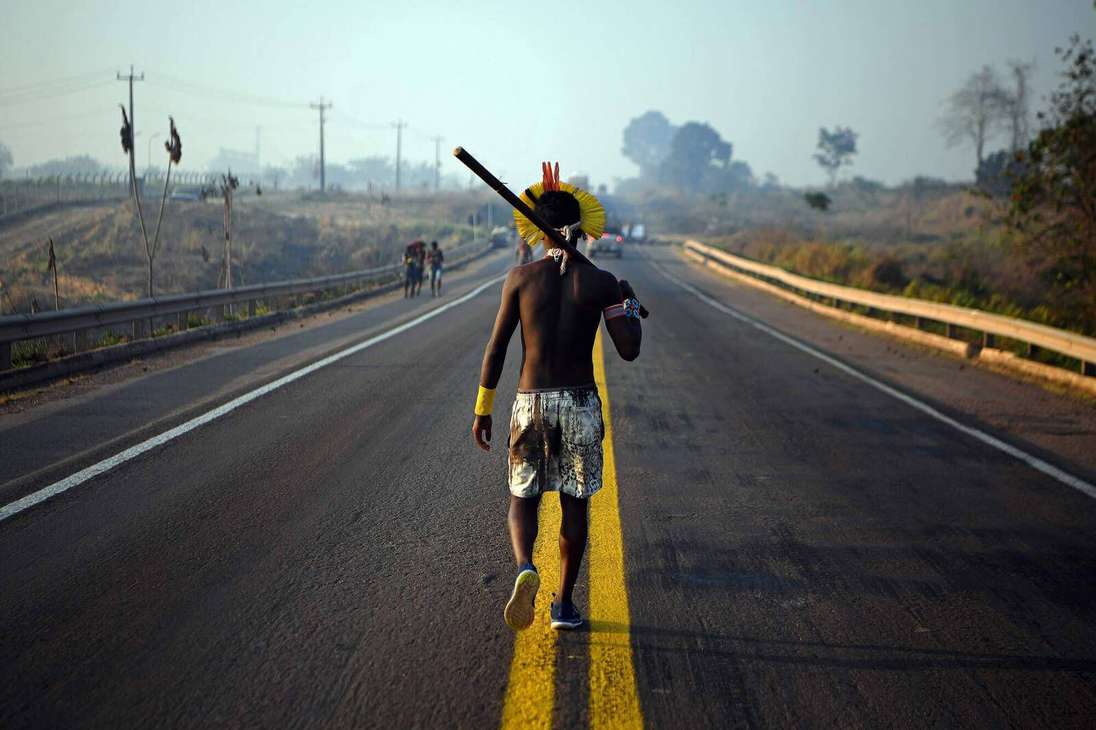 Un miembro de la tribu Kayapo camina por el medio de la carretera BR163 durante una protesta, por la falta de ayudas contra el Covid 19, en el estado de Pará, Brasil, el 17 de agosto de 2020.