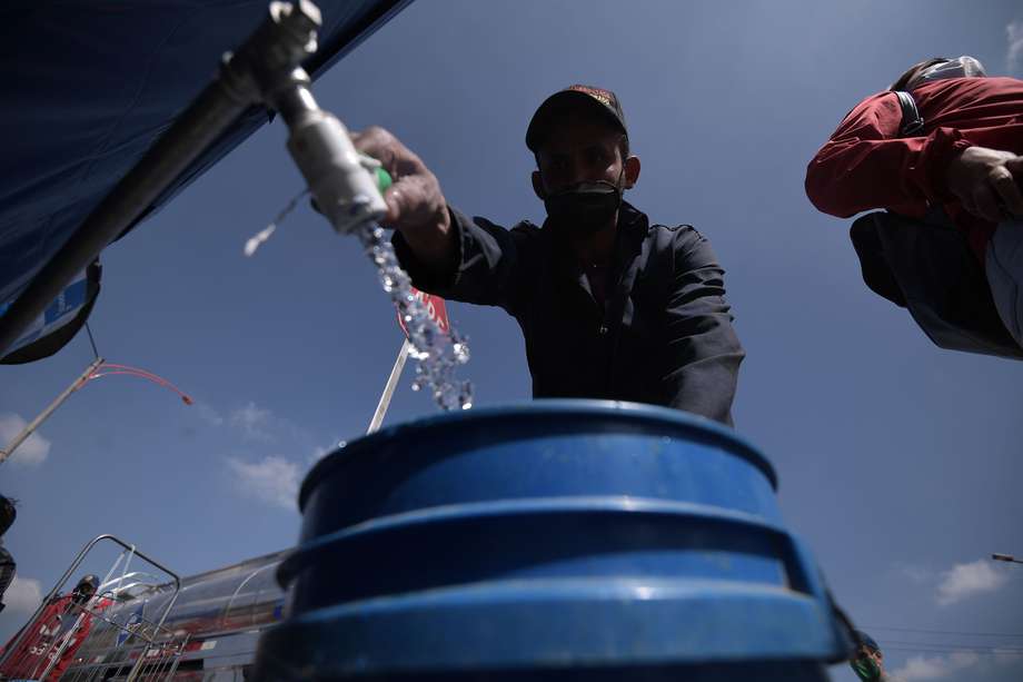 Bogotanos se abastecen de agua potable en carrotanques, tras la suspensión del servicio.
