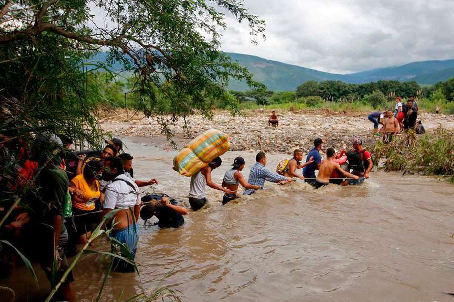 Migrantes venezolanos cruzaron el río Táchira, en la frontera con Colombia, para dejar su país; usan esta vía por cuenta del cierre del paso fronterizo. / AFP