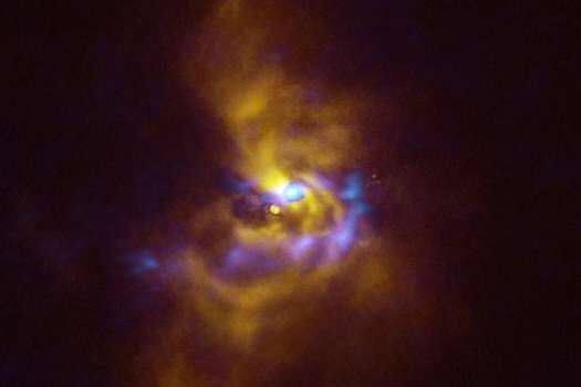 En el centro de esta imagen está la joven estrella V960 MON, ubicada a más de 5000 años luz de distancia en la constelación de Monoceros. Material polvoriento con potencial para formar planetas rodea a la estrella. /ESO/ALMA (ESO/NAOJ/NRAO)/WEBER ET AL.