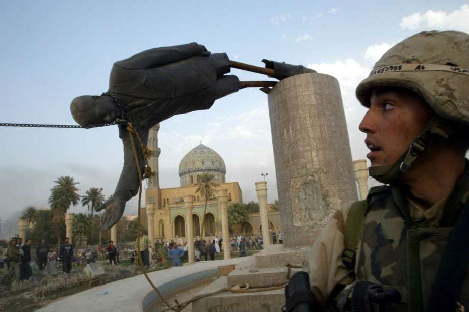 Un miembro de los Marines de EE. UU. observa cómo cae una estatua del presidente de Irak, Saddam Hussein, en el centro de Bagdad.