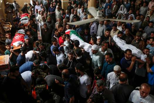 Palestinos se reúnen alrededor de los muertos que dejó el ataque israelí. / AFP