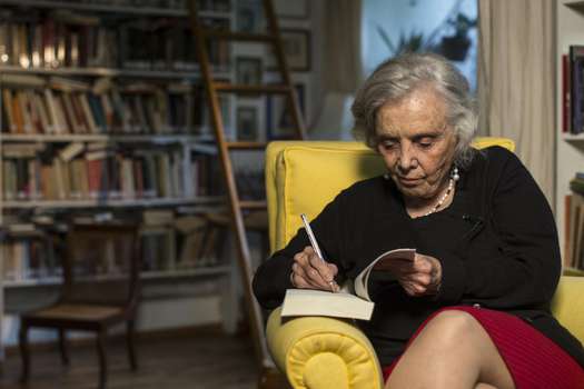 Mexican writer Elena Poniatowska signs her new novel during an interview inside her home in Mexico City, Thursday, Sept. 24, 2015. Surrounded by her books, Poniatowska spoke about her latest novel "Dos veces unica," concerning the life of Lupe Marin, Diego Rivera's first wife. (AP Photo/Christian Palma)