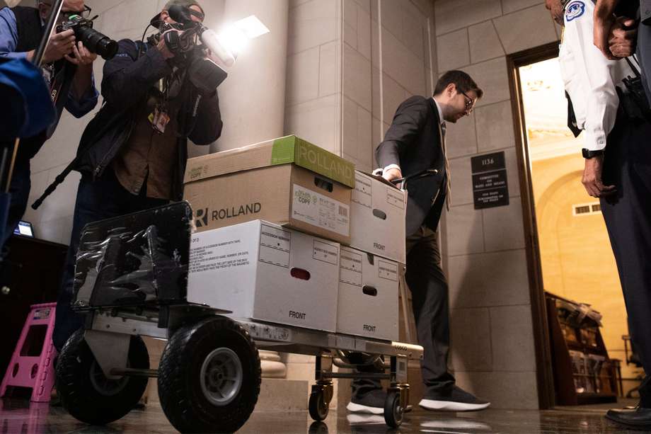 Un miembro del personal del Congreso (C) es escoltado por la Policía del Capitolio (R) mientras tira de un carro de cajas de documentos con las declaraciones de impuestos del expresidente estadounidense Donald J. Trump.