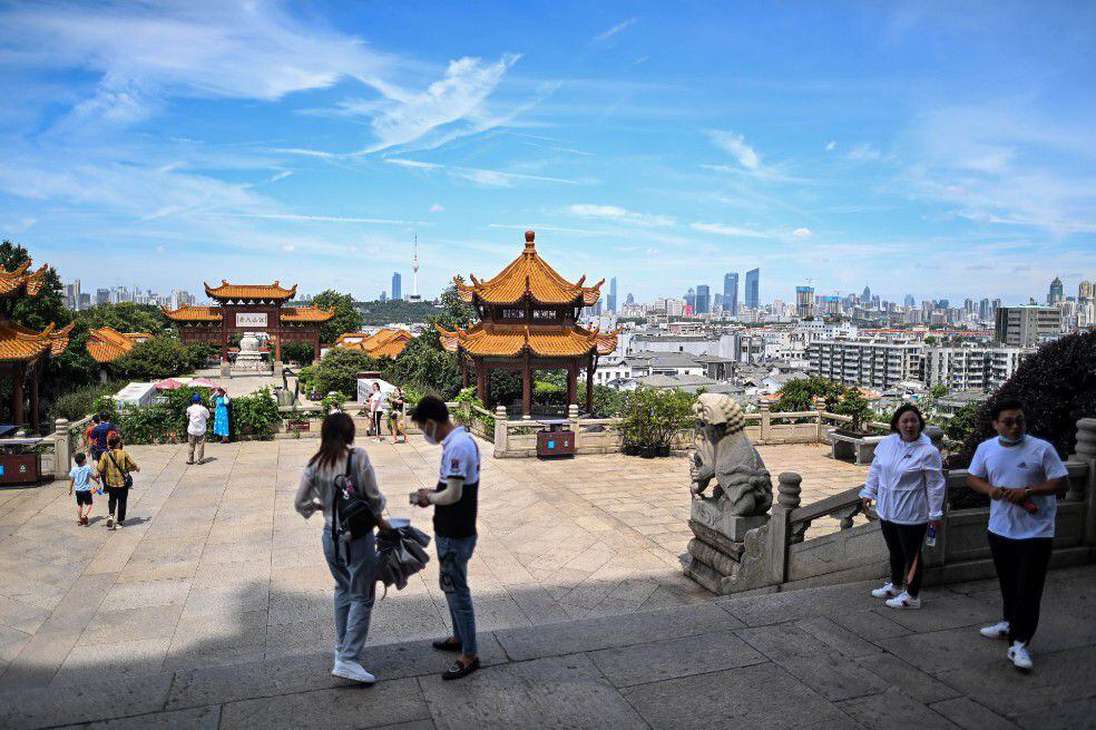Los turistas volvieron y se fotografían sonrientes frente a la Torre de la Grulla Amarilla, uno de los monumentos emblemáticos de Wuhan, con sus artesanías rojas y naranjas.