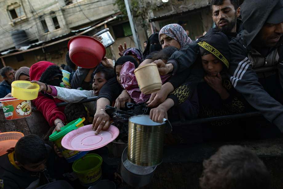 Palestinos desplazados se reúnen para recoger alimentos donados por un grupo benéfico, 14 de marzo de 2024.

