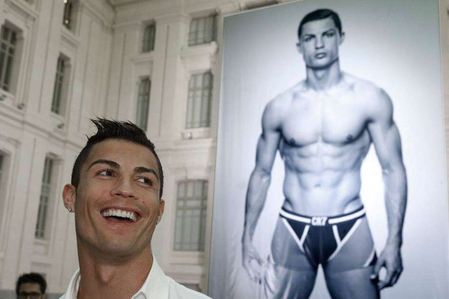 El delantero del Real Madrid Cristiano Ronaldo posa junto a un póster gigante con su imagen instalado en el Patio de Cristal del Palacio de Cibeles, Madrid. / Efe