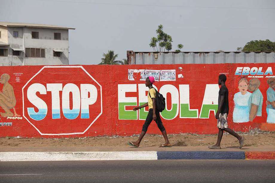 MNR02. Monrovia (Liberia), 22/03/2015.- Liberians walk pass an ebola awareness painting on a wall in downtown Monrovia, Liberia, 22 March 2015. Liberia has confirmed a new case of Ebola, undermining growing hopes in the country that it might soon be declared free of the disease. There had not been a new case for 20 days until a woman tested positive on 22 March in the capital, Monrovia. March 22nd 2015. EFE/EPA/AHMED JALLANZO