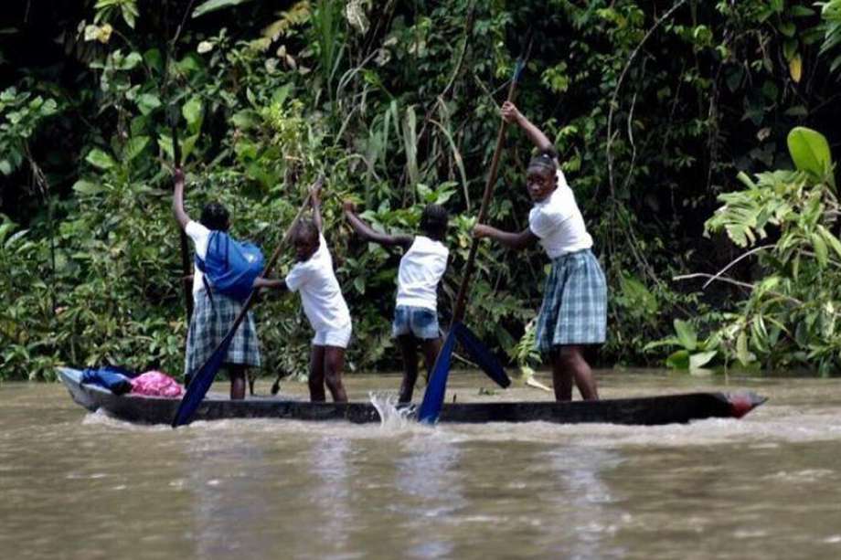 Niñas reman en una canoa por el río Naya, entre Cauca y Valle del Cauca, para llegar al colegio.