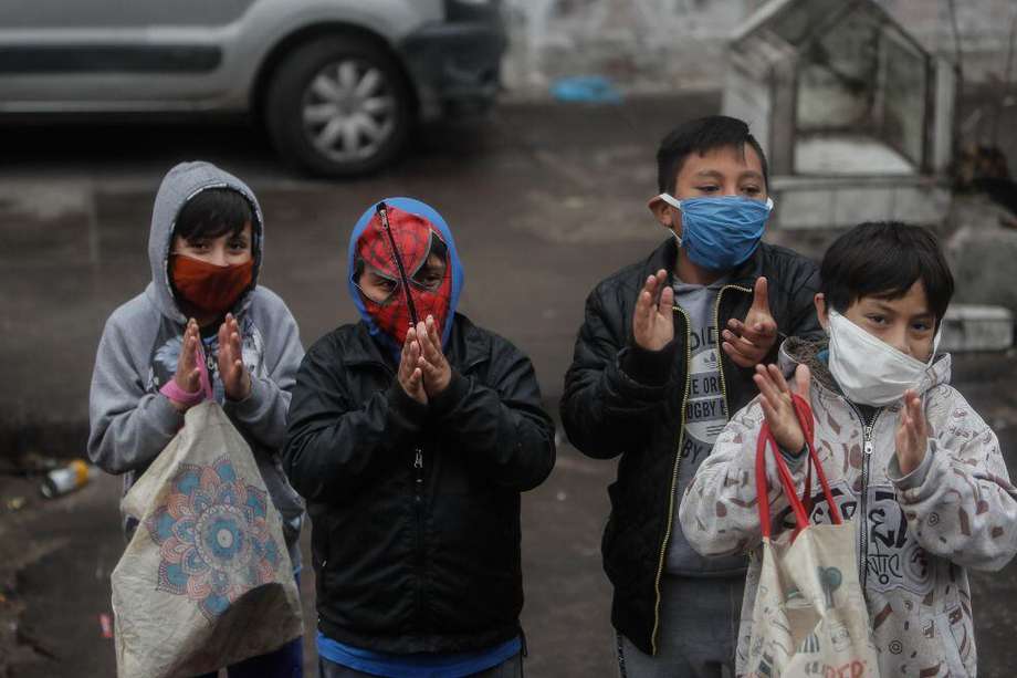 Un grupo de niños aplaude frente a un comedor comunitario en Argentina; se calcula que 22% de niños en América Latina serán pobres tras la pandemia.