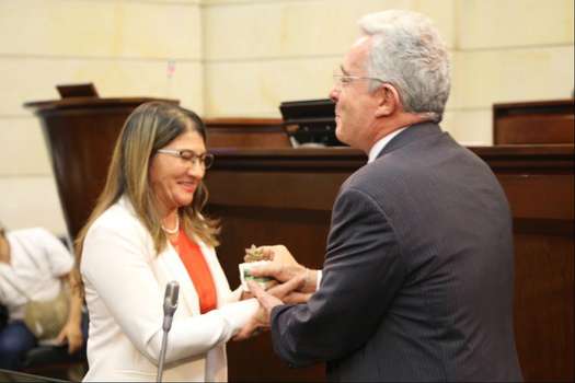 En una plenaria del Senado en 2018, el senador del Centro Democrático recibió de manos de Griselda Lobo una planta que representaba simbólicamente la familia colombiana y la construcción de la paz. /Archivo particular
