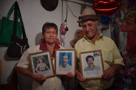 Isaura Quiceno y Reinaldo Cardona sosteniendo los retratos de sus hijos.