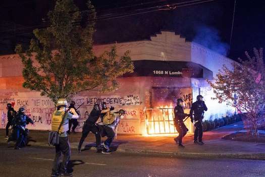 La policía de Portland dispersa a una multitud después de que los manifestantes prendieran fuego al edificio de la Asociación de Policía de Portland.
