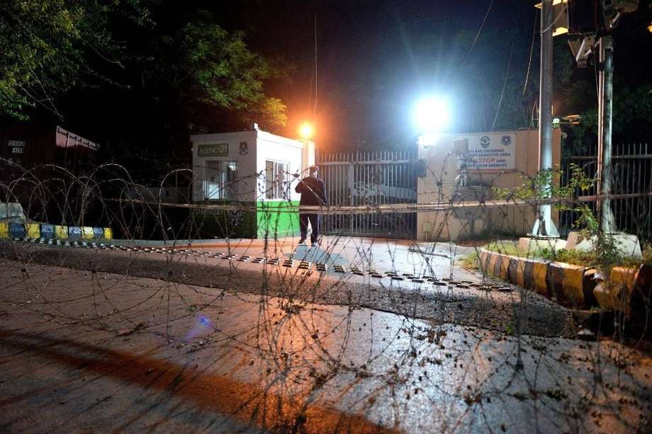 Funcionarios de seguridad paquistaníes instalan alambres de púas en una carretera que conduce a la embajada francesa para reforzar la seguridad.