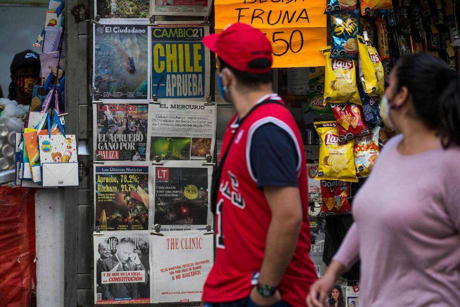 Transeúntes en Santiago de Chile revisan las portadas de los diarios que reportan del triunfo del "aprueba" que debe llevar a una nueva Constitución.