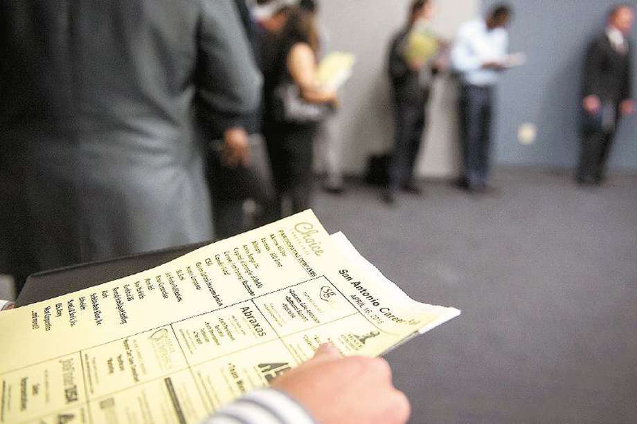 Un solicitante de empleo sostiene una solicitud mientras espera en la fila para ingresar a la feria Choice Career Fair en San Antonio, Texas.