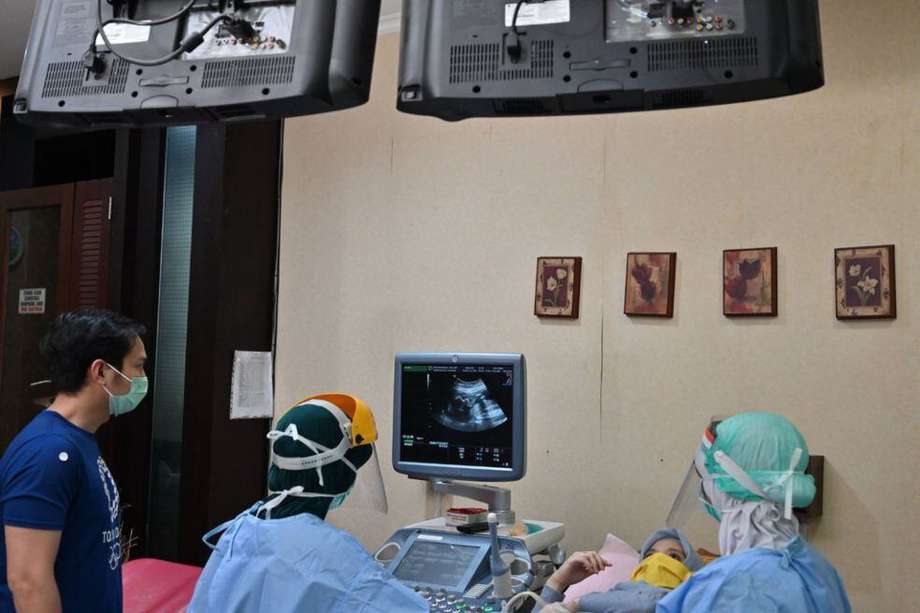 un obstetra-ginecólogo examina los escáneres de una mujer embarazada en un hospital en Yakarta en abril.