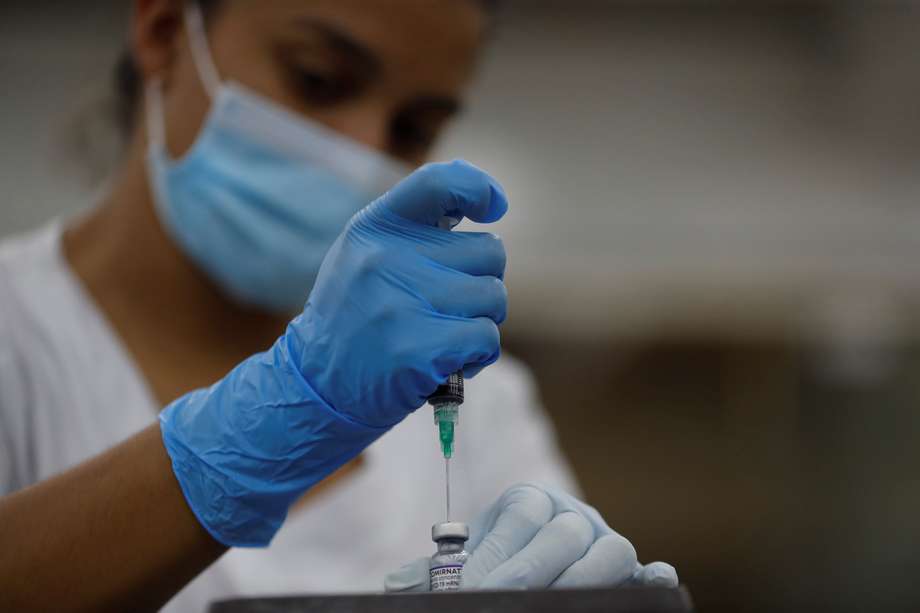 AME6422. CALI (COLOMBIA), 17/02/2022.- Una enfermera prepara una dosis de la vacuna de Pfizer contra la covid-19, el 16 de febrero de 2022 en Cali (Colombia). La campaña de vacunación contra la covid-19 en Colombia, que comenzó lentamente y después que en la mayoría de países latinoamericanos, superó en un año los obstáculos burocráticos y geográficos para reducir sustancialmente las muertes y hospitalizaciones por coronavirus. EFE/Ernesto Guzmán
